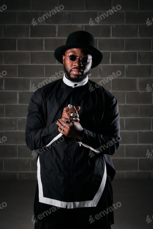 Preview: Serious man in stylish outfit at brick wall