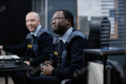 Preview: Middle Aged Caucasian Man and Young Adult Black Man Working in Security Office