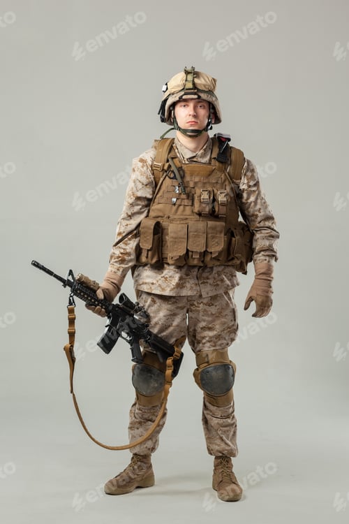 Preview: Soldier in combat gear stands with rifle in a studio setting during daylight hours
