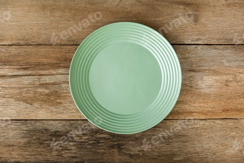 Preview: Top view of empty green plate on a wooden background. Flat lay, copy space.