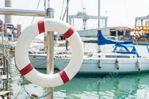 Preview: Life buoy hung on a railing in the port.
