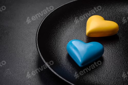 Preview: Chocolate hearts in the colors of the Ukrainian flag on a black ceramic plate
