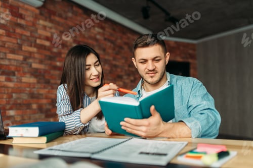 University students reading textbook together