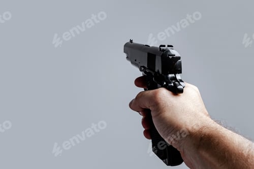 Preview: First person view of male hand with black pistol isolated on gray background