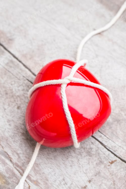 Preview: Hearts tied with a rope on a wooden