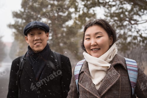 Preview: Happy young asian couple in love at walk in winter city park