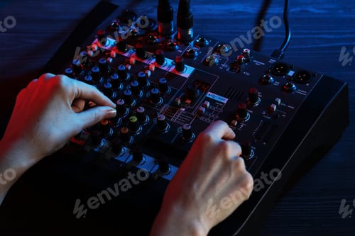Preview: Woman working with professional mixing console at wooden table, closeup