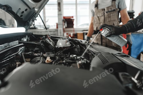 Preview: Close up of mechanic's hands repairing car engine in car service