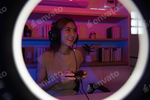 Preview: Gaming and Digital Entertainment. Young woman enjoying video game in colorful room with headphones.
