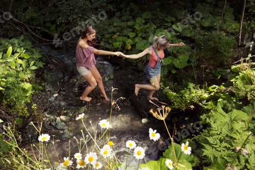 Preview: Two female friends crossing stream, Sattelbergalm, Tyrol, Austria