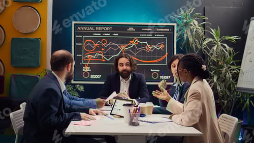 Preview: Startup team evaluating infographics data in an executive meeting,