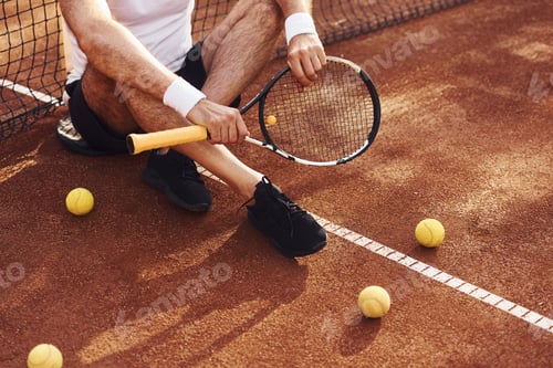 Preview: Close up view of senior man in white shirt and black sportive shorts that is on tennis court