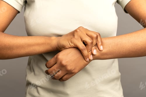 Preview: Black female arms massaging painful wrist suffering from weakness and tingling. Sport injury disease