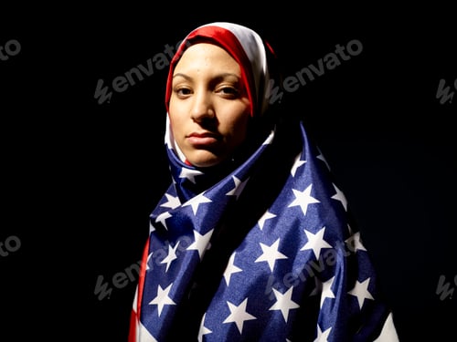 Preview: A woman draped in an American flag hijab looks contemplatively to the side against a black