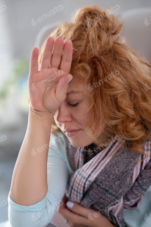 Preview: Woman With Headache Sitting Indoors Near Window