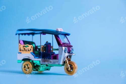 Preview: Model Toy tuk tuk isolated on blue background. Thai traditional taxi in Bangkok Thailand. Souvenir