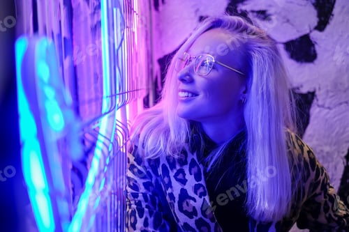 Preview: Woman face with glasses in metal frame reflect purple neon light