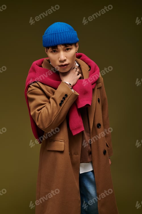 Preview: Stylish Asian man poses confidently in a cozy outfit against a warm backdrop