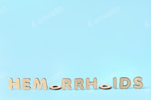 Preview: Concept of hemorrhoids with wooden letters on blue background