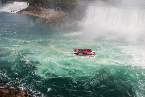 Preview: Minimalistic view of boat with tiny people in Niagara Falls with rainbow reflection on the water.