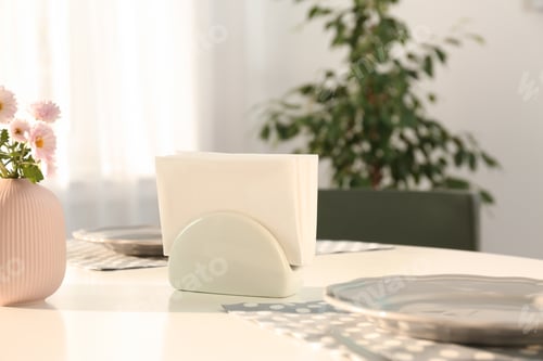 Preview: Ceramic napkin holder with paper serviettes on table indoors