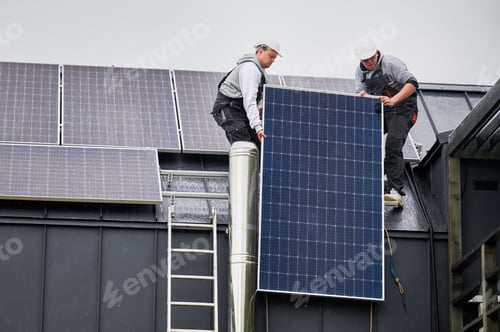 Preview: Workers lifting up photovoltaic solar module while installing solar panel system on roof of house.