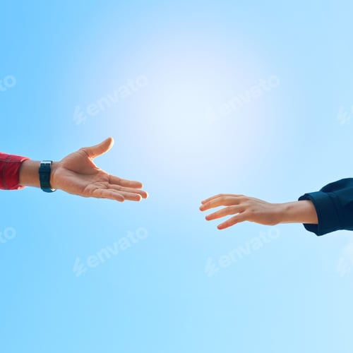 Preview: Shot of two unidentifiable hikers reaching for each others hands against a clear blue sky