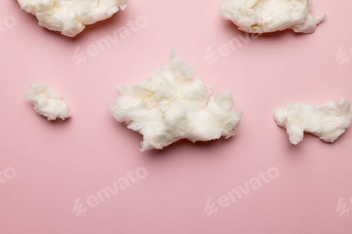 Preview: Horizontal image of tufts of homemade white candy floss, on pink background