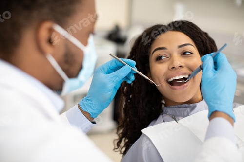 Preview: Young African American Woman Having Check Up With Dentist In Modern Clinic