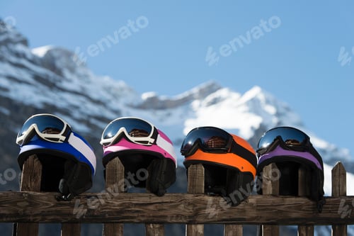 Preview: Four skiing helmets on wooden fence
