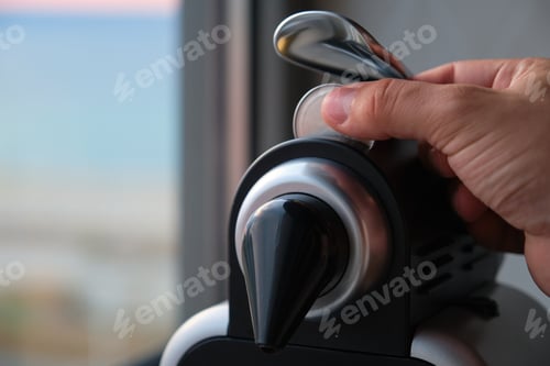 Preview: Close up of a hand preparing coffee in a coffee machine with capsules.