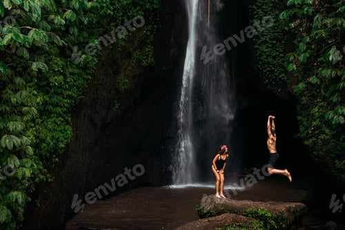 Preview: Happy couple having fun at a waterfall in Bali. A couple having fun at a waterfall in Indonesia