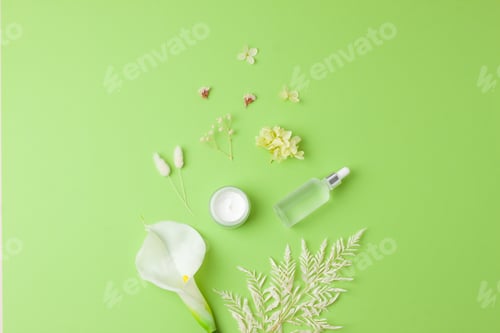 Preview: Cosmetic skin care products with flowers on green background. Flat lay, copy space