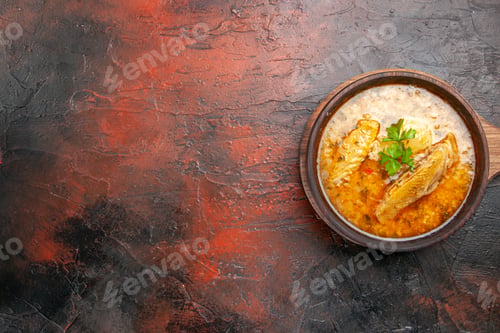 Preview: top view chicken soup in wooden bowl with handle on dark red background with free space