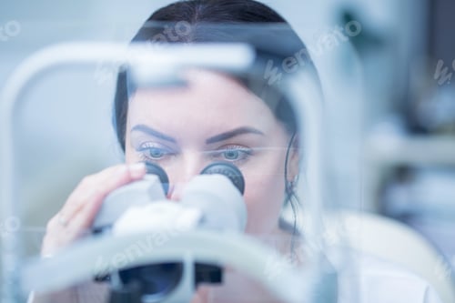 Preview: ophthalmologist woman looks into the viewfinder of a slit lamp