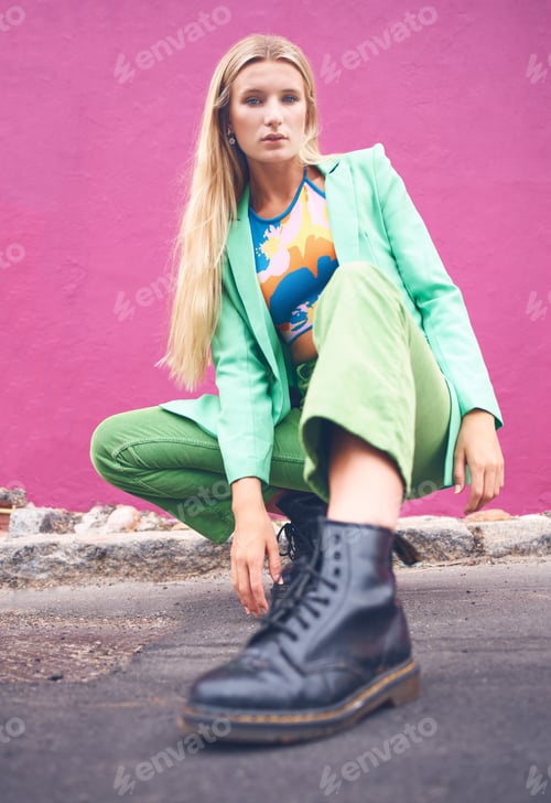 Preview: Fashion content creator and social media influencer in neon clothes and cool modern pose outdoors o