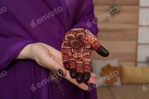 Preview: Woman with henna tattoo on palm indoors, closeup. Traditional mehndi ornament