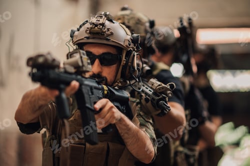 Preview: Group of armed forces with rifles in action preparing for combat.