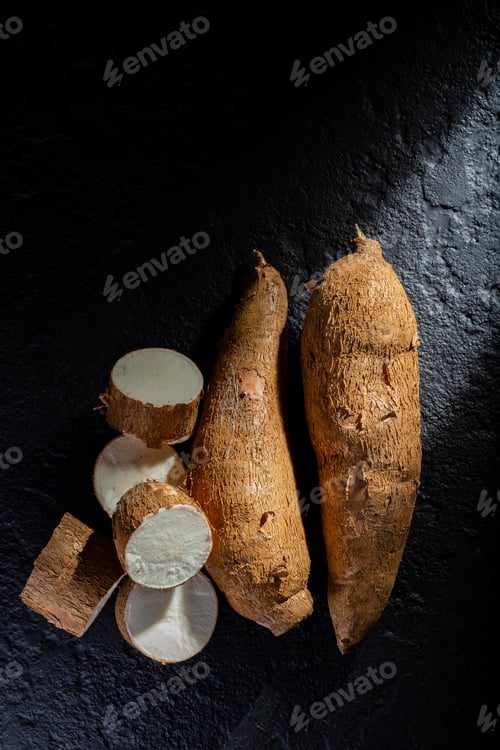 Preview: pile of cassava and cassava flour on dark background (Manihot esculenta)