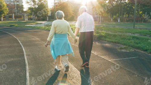 Preview: Senior couple walking along the running track