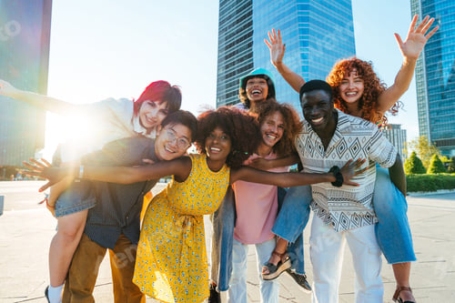 Preview: Multiethnic group of young friends meeting and having fun outdoors