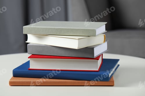 Preview: Stack of hardcover books on white table, closeup
