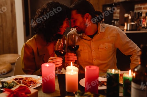 Preview: White couple hugging while having romantic dinner at home