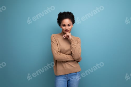 Preview: positive young authentic latino woman with afro hair tied up in a ponytail against the background