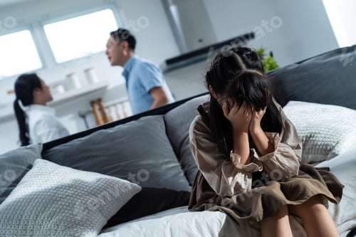 Preview: Asian girl kid sitting and crying while parents having fighting or quarrel conflict at home.