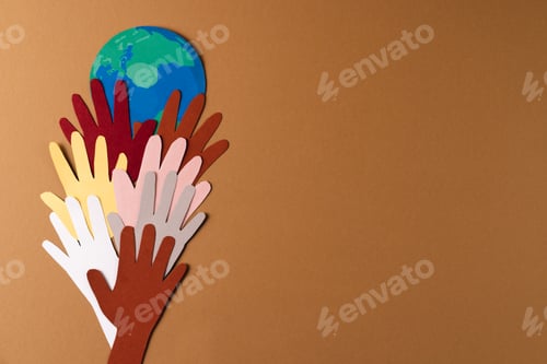 Preview: Paper cut out of multi coloured hands and globe with copy space on brown background