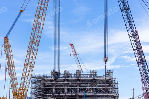 Preview: Construction site with construction crawler cranes and multi storey unfinished buildings