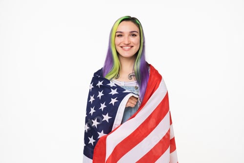 Preview: Happy smiling caucasian teenage girl hipster embracing covering with American USA flag