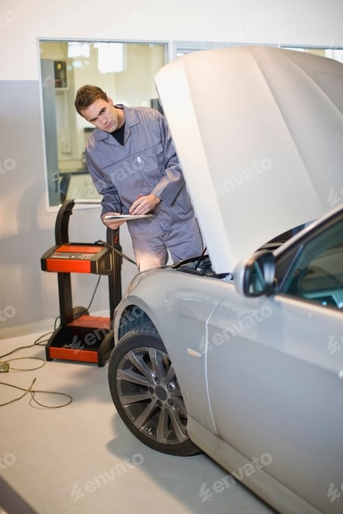 Preview: Mechanic examining car engine in garage