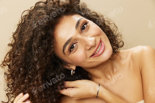 Preview: Woman applies cream and balm to her curly hair, the concept of protection and care, a healthy look